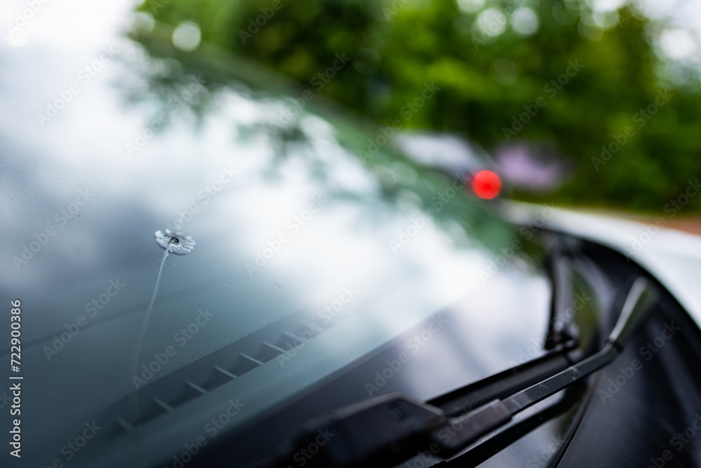 detail of a broken window by a stone in a car on the highway - the cost of replacing the windshield