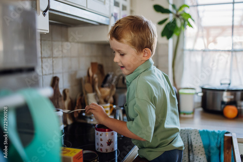 Bilde på lerret Boy helping with breakfast in home kitchen in the morning