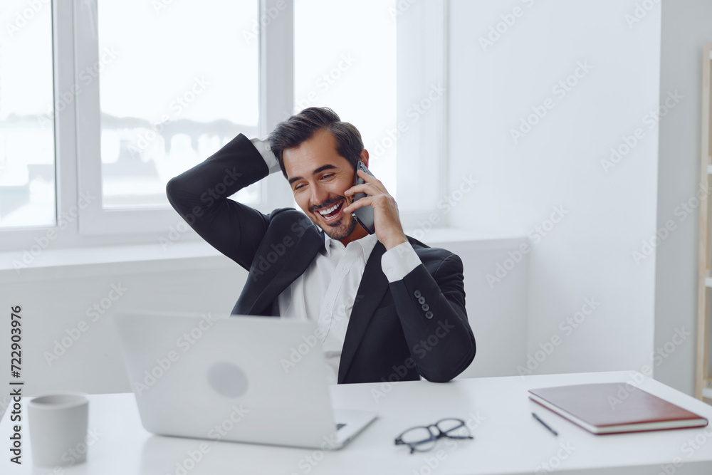 Man in office businessman sitting at desk and working in laptop and talking on phone, modern suit, finance and startup concept and data analysis, working lifestyle in bright office. Man in office businessman sitting at desk and working in laptop and talking on phone, modern suit, finance and startup concept and data analysis, working lifestyle in bright office.