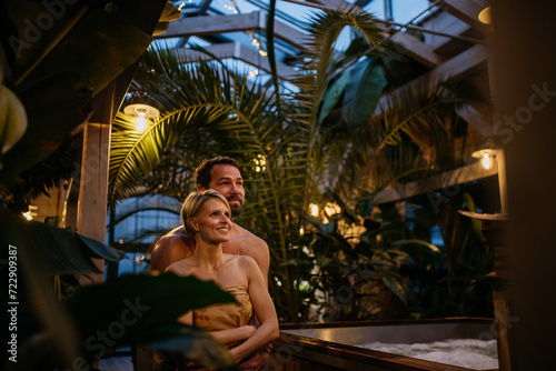 Beautiful couple standing in hotel greenhouse, enjoying romantic wellness weekend in spa. Concept of Valentine's Day. © Halfpoint