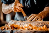 A skilled artisan's hands work diligently with a chisel, carving an intricate design into a block of wood, surrounded by curls of wood shavings.