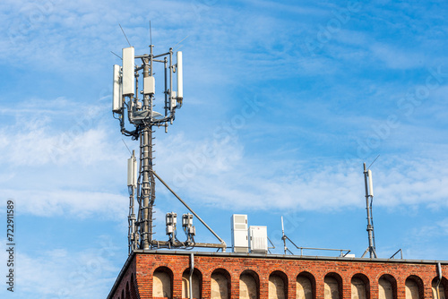 Antenne für den mobilen Funkverkehr auf dem Dach eines Gebäudes vor blauem Himmel photo