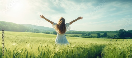 girl in green field with open arms dancing and enjoying nature. Creative Banner. Copyspace image photo