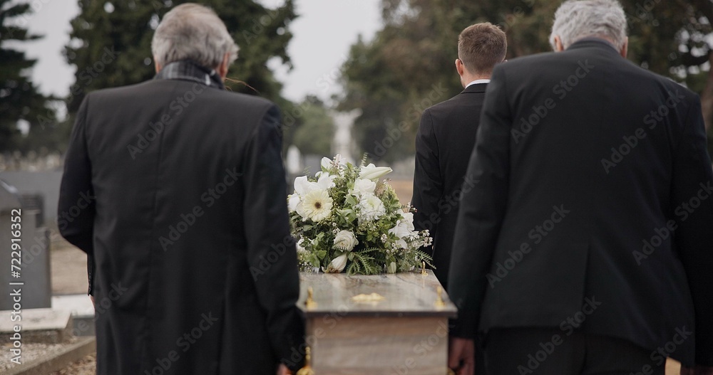 Men, coffin and pallbearers walking at cemetery ceremony outdoor at