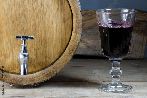 a glass of wine near a barrel