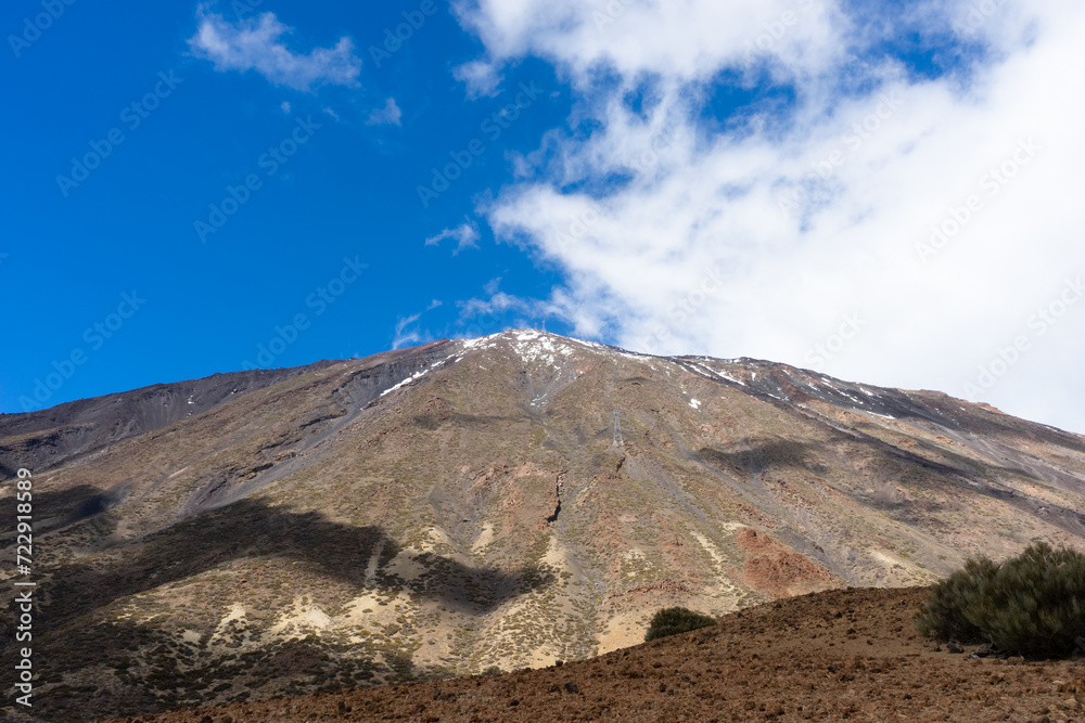Amazing volcano Del Teide with a wide angle view and white clouds,  beautiful shadows and blue sky. Tenerife, Canary Islands, Spain.