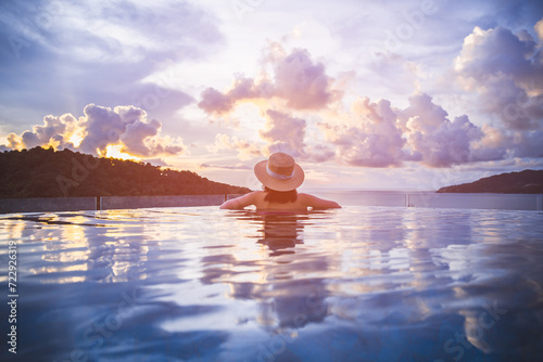 Asian traveler bikini woman relax and travel in infinity pool resort on phuket beach Thailand © Peera