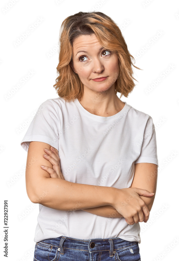 Blonde middle-aged Caucasian woman in studio dreaming of achieving goals and purposes