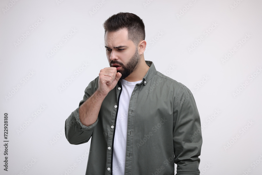 Sick man coughing on white background. Cold symptoms
