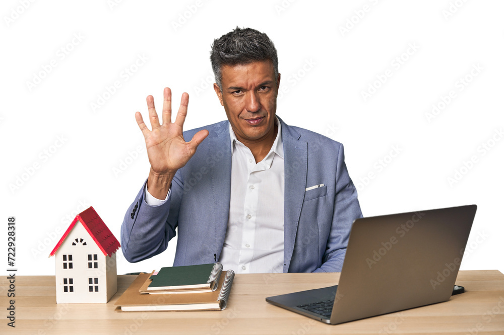 Middle-aged Hispanic businessman with real estate theme smiling cheerful showing number five with fingers. Middle-aged Hispanic businessman with real estate theme smiling cheerful showing number five with fingers.