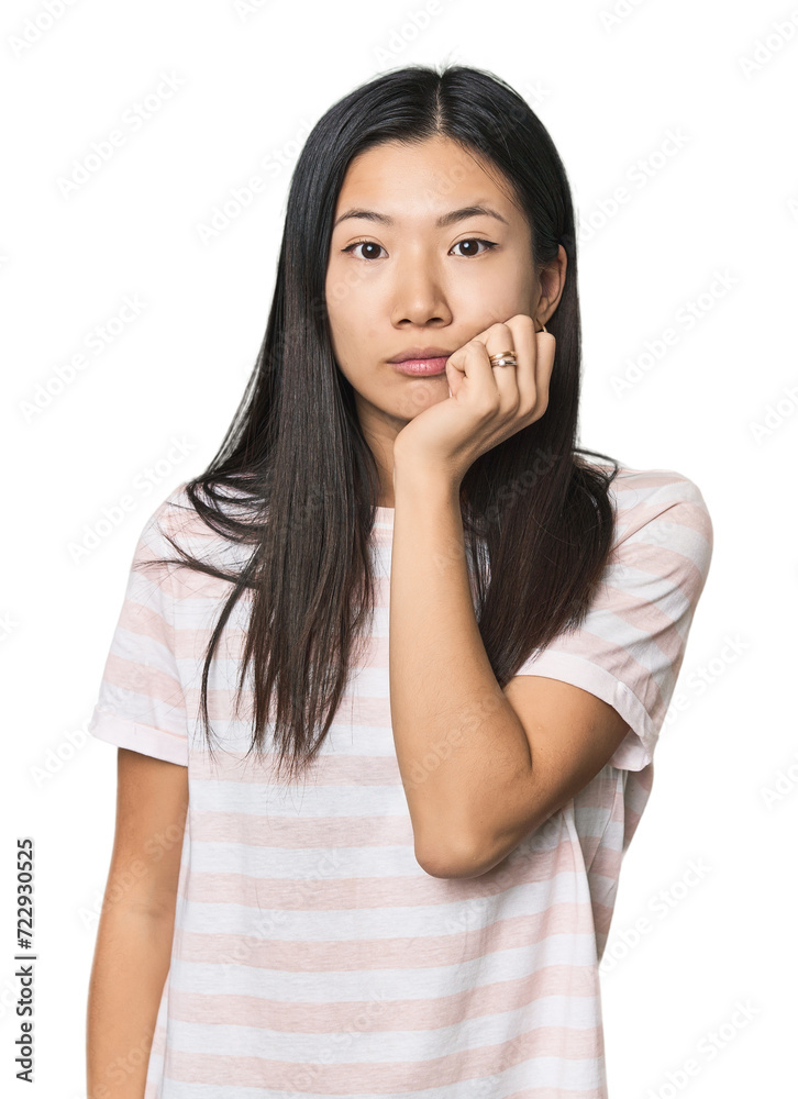 Young Chinese woman in studio setting biting fingernails, nervous and very anxious. Young Chinese woman in studio setting biting fingernails, nervous and very anxious.