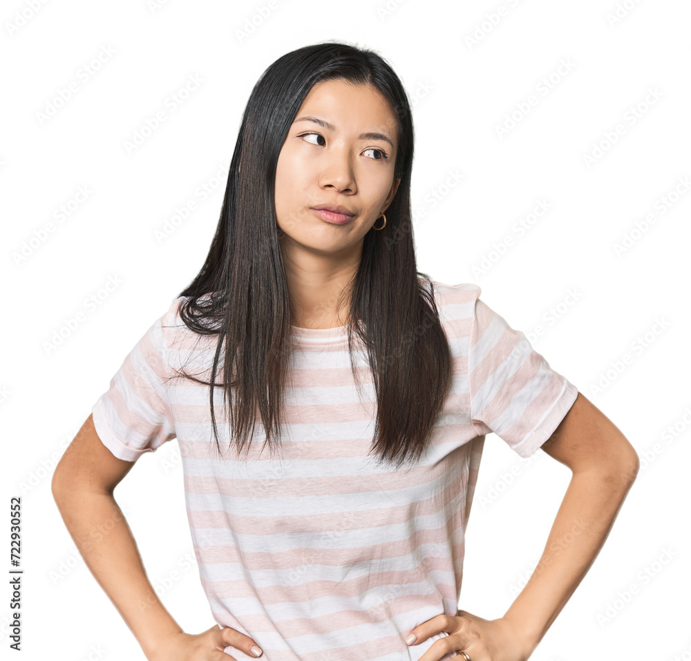 Young Chinese woman in studio setting confused, feels doubtful and unsure. Young Chinese woman in studio setting confused, feels doubtful and unsure.