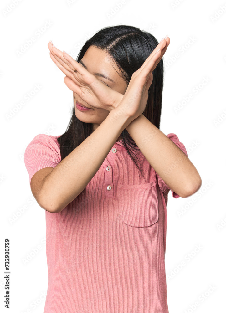 Young Chinese woman in studio setting keeping two arms crossed, denial concept. Young Chinese woman in studio setting keeping two arms crossed, denial concept.