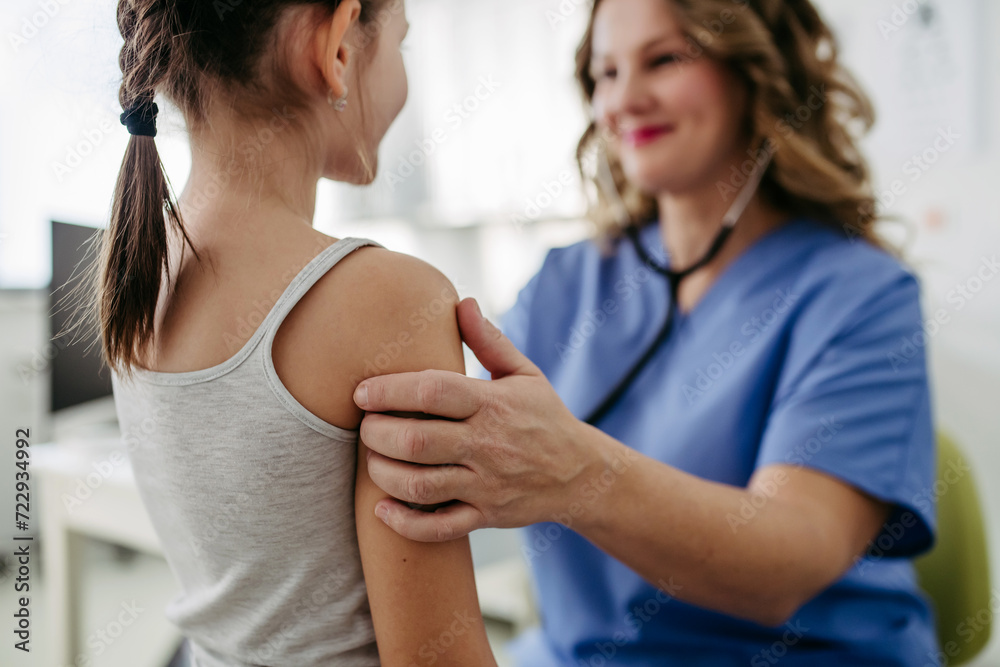 Orthopedist examines the spine, posture, and spinal deformities of little girl. Girl visiting paediatrician for annual preventive exam. Concept of preventive health care for children. Orthopedist examines the spine, posture, and spinal deformities of little girl. Girl visiting paediatrician for annual preventive exam. Concept of preventive health care for children.