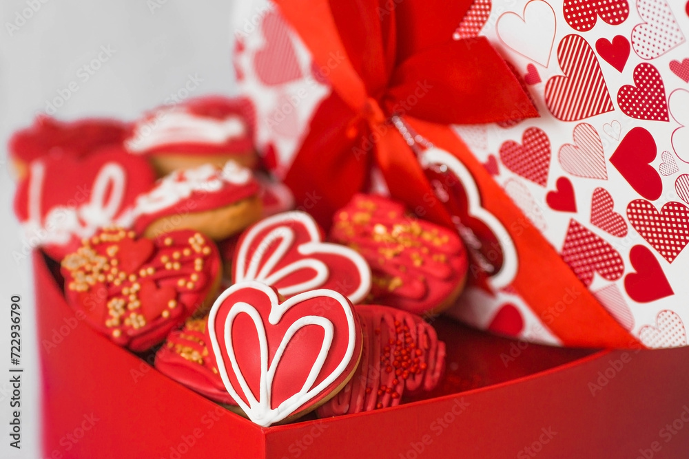 Homemade ginger cookies in the shape of a heart in red icing sugar. Delicious ginger cookies heart on a light concrete background. Freshly baked gingerbread cookies for Valentine's Day.