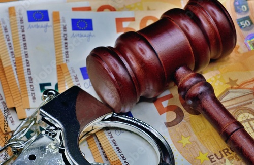 Obraz na plátně Euro bills and judge hammer with police handcuffs on court desk