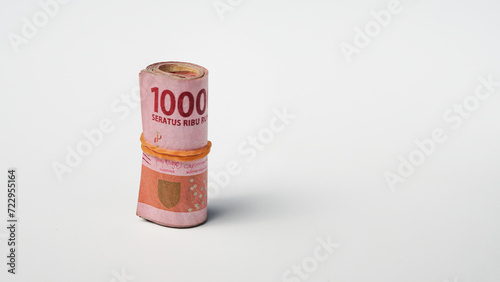 roll of rupiah banknotes tied with rubber on a white background
