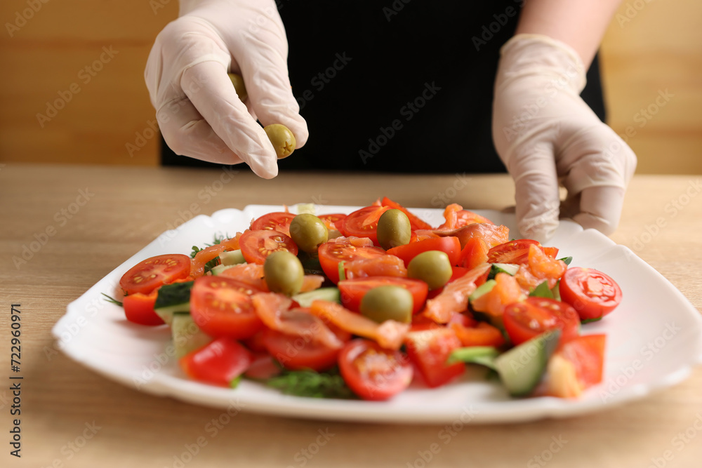 Olives are added to vegetable salad. Preparation of vegetable salad