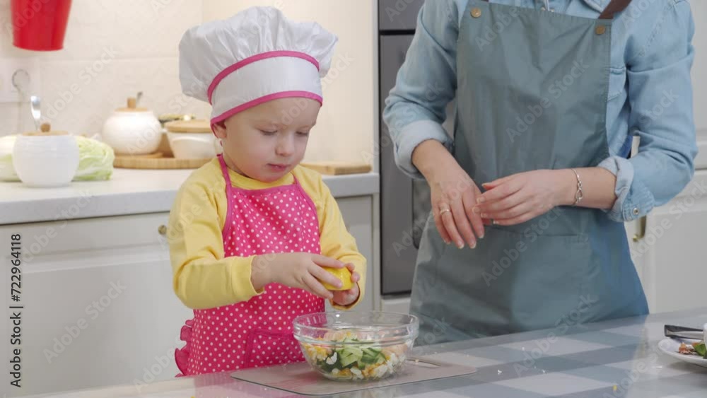 Mother with child preparing dinner together in modern kitchen at home, little boy helping mom cooking vegetable salad with shrimp. Mother with child preparing dinner together in modern kitchen at home, little boy helping mom cooking vegetable salad with shrimp.