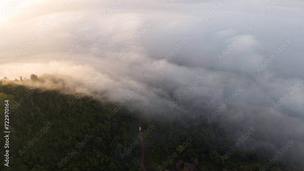 Aerial Drone Shot of mist in Valley with sunset and view of coastal town and trees and buildings early morning