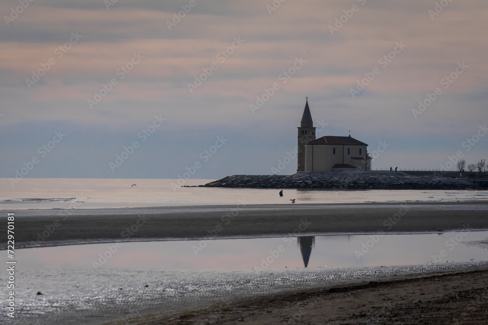La chiesa della Madonna dell'Angelo sul lungomare di Caorle, cittadina di mare vicino a Venezia, si riflette nell'acqua