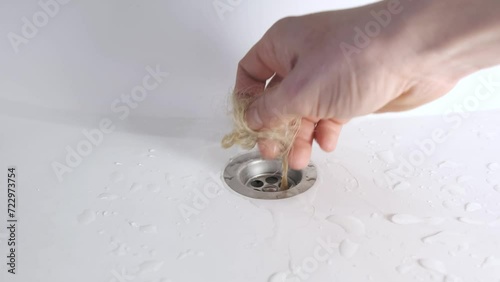 A man takes wet hair out of the sink and bathroom with his hand. sewage treatment.