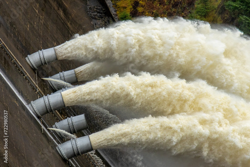 Laggan dam with powerful water flowing through pipes photo