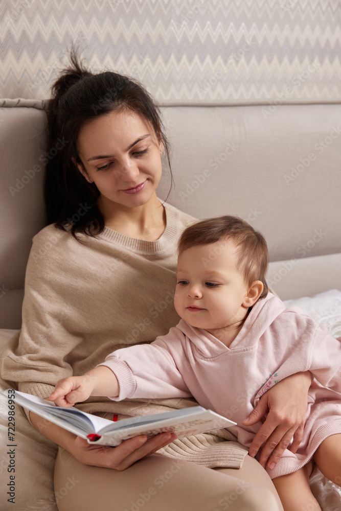 beautiful mother reading book to her child daughter on bed beautiful mother reading book to her child daughter on bed
