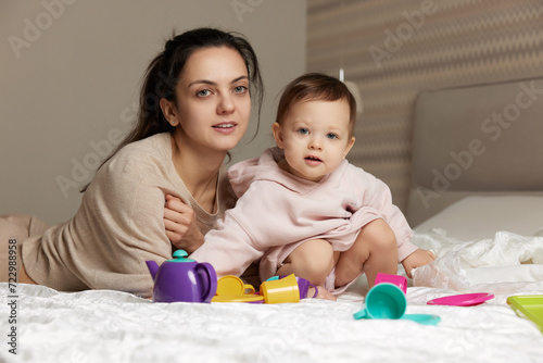 mother and cute little child daughter playing tea party and spending time together in bedroom