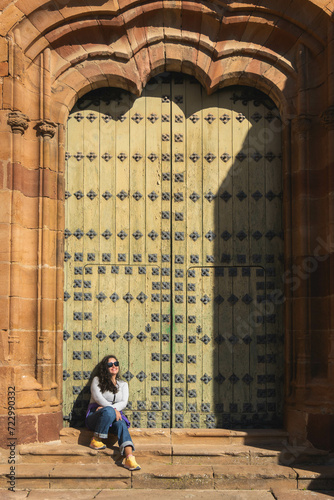 Mujer sentada frente a un portal mirando al horizonte