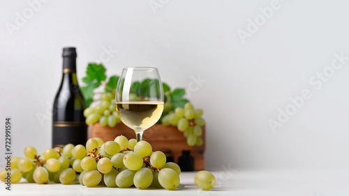 Foto bunches of white grapes with green leaves and a glass of white wine and a bottle