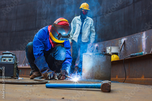 Welding male worker metal arc part in nozzle storage top tank roof