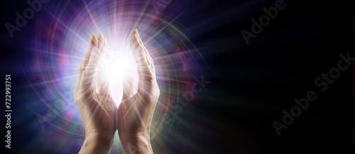 Sending Quantum Healing Concept Template - Male Reiki Master Healer with parallel hands reaching into white star orb light against multicoloured vortex energy field with copy space for spiritual messa