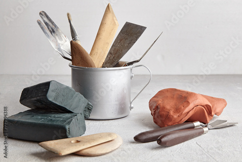Sculptor and potter tools and pieces of clay in a sculpture workshop on a gray concrete table