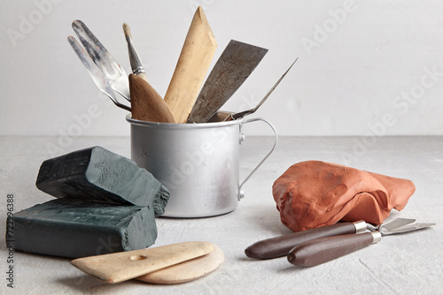 Sculptor and potter tools and pieces of clay in a sculpture workshop on a gray concrete table photo