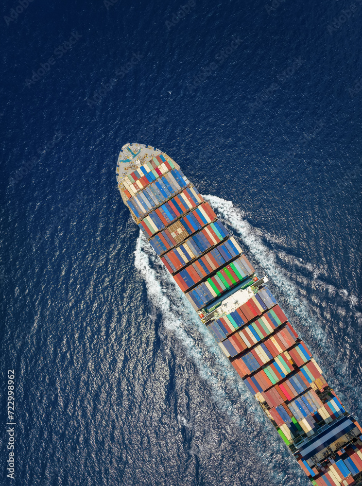 Aerial top down view of a large container cargo ship in motion over open ocean as a concept for import and export industry