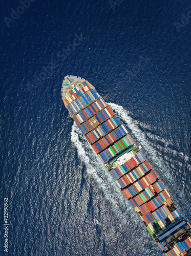 Obraz na płótnie Aerial top down view of a large container cargo ship in motion over open ocean as a concept for import and export industry w salonie