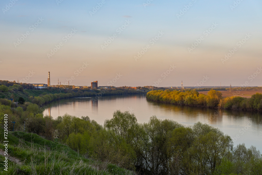 Industrial landscape near the river, large factory next to the river