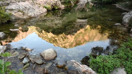 Reflection of mountain on the surface of a river flowing through a canyon