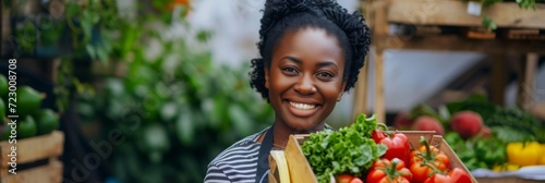 Smiling Woman Holding a Box of Fresh Vegetables