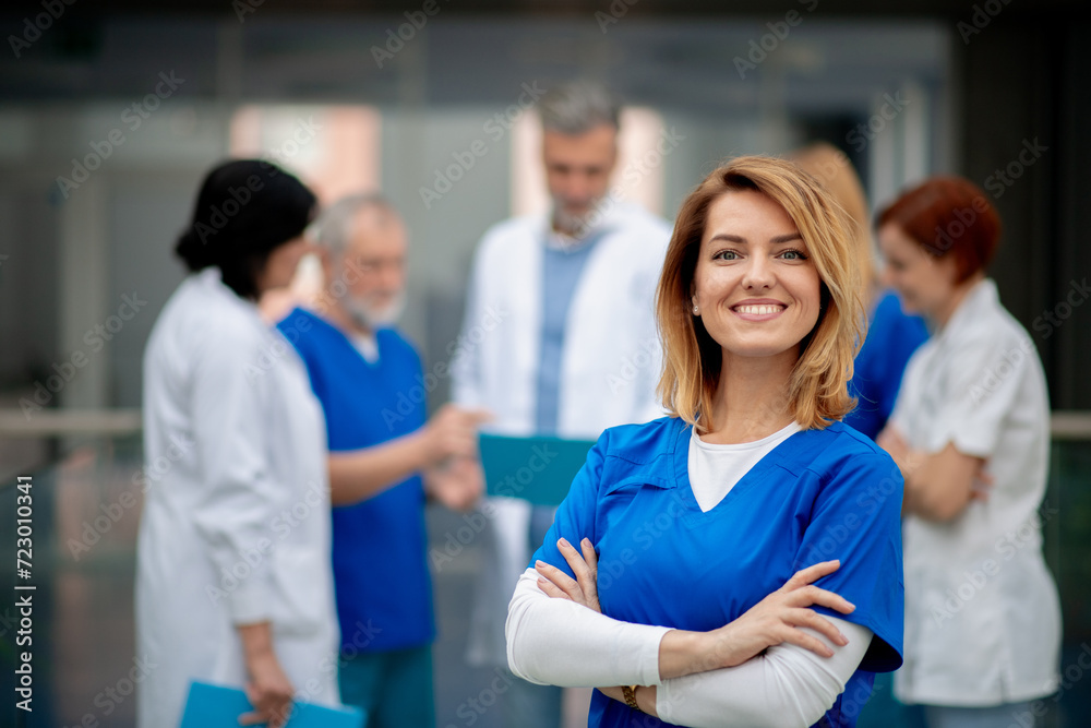 Portrait of beautiful female doctor standing in front of team of doctors. Colleagues, doctors team discussing patients diagnosis.
