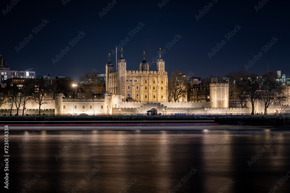A general view of The Tower of London at night time with light reflections on the Thames river. Long exposure night photography.