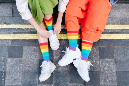 Young lesbian couple wearing multi colored socks at footpath photo