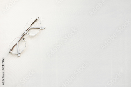 metal-framed glasses on a light background. free space for text. photo from above