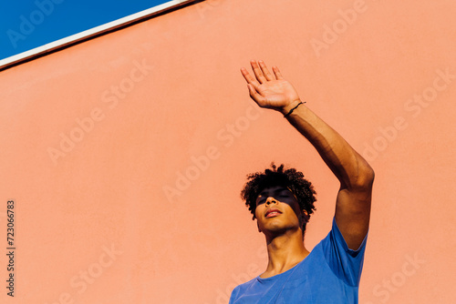 Young man shielding eyes from sunlight photo
