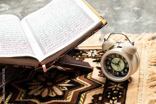 Islamic Holy Book Quran with alarm clock Ramadan Concept.