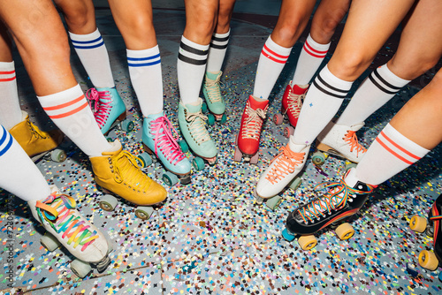 Legs of women wearing roller skates over confetti photo