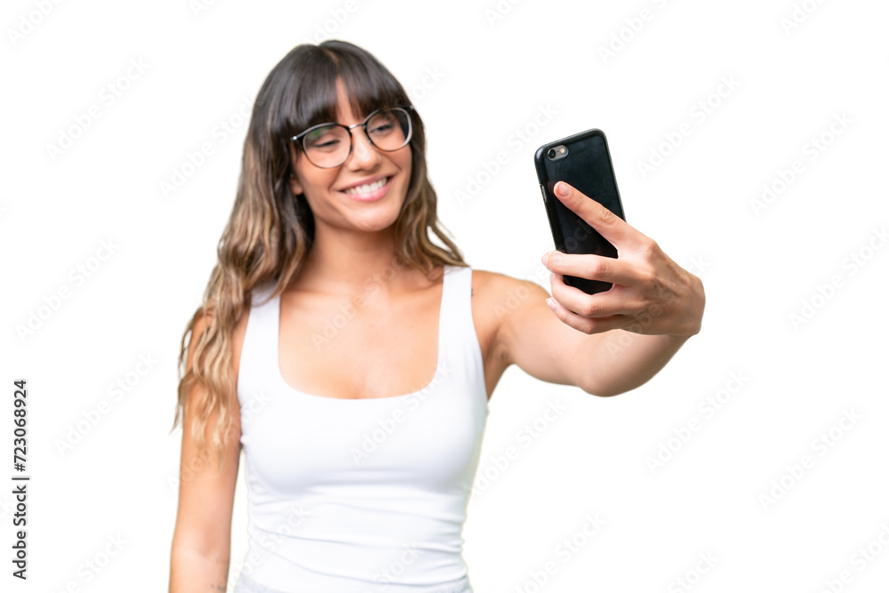Young caucasian woman over isolated background making a selfie with mobile phone Young caucasian woman over isolated background making a selfie with mobile phone
