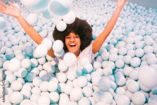 Playful young woman playing in ball pool photo