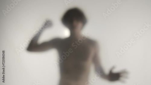Wallpaper Mural A blurred silhouette of a man with a bare torso behind a frosted curtain or glass. A man beating his fist, trying to break an invisible barrier, bowing his head in hopelessness. Ghost concept. HDR Torontodigital.ca